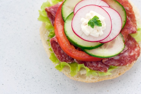 Delicious ham, cheese and salami sandwich with vegetables, lettuce, cherry tomatoesの写真素材