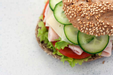 Delicious ham, cheese and salami sandwich with vegetables, lettuce, cherry tomatoesの写真素材