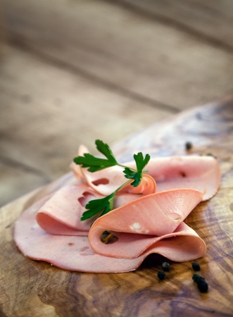 Italian salami mortadella on wooden olive backgroundの写真素材