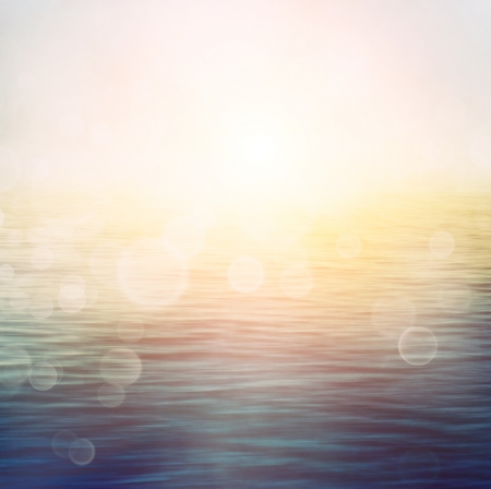 Abstract nature summer or spring ocean sea background  Small waves on water surface in motion blur with bokeh lights from sunrise の写真素材