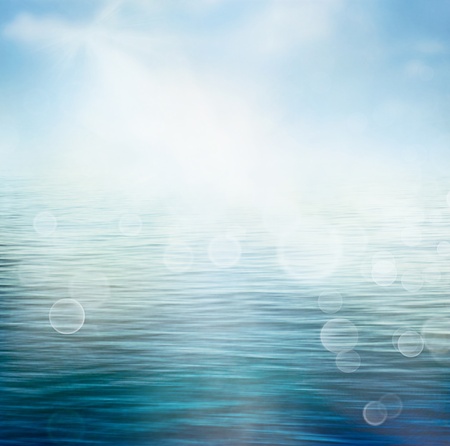Abstract nature summer or spring ocean sea background  Small waves on water surface in motion blur with bokeh lights from sunrise の写真素材