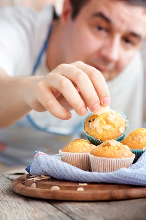 Chef is decorating delicious organic muffins  Almond and cherry cup cakes in natural setting の写真素材