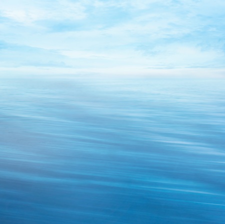 Abstract nature summer or spring ocean sea background  Small waves on water surface in motion blur with bokeh lights from sunrise の写真素材