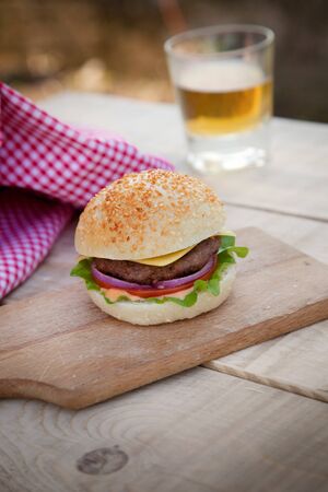 Delicious hamburger in rustic setting  Burger on wooden board with beerの写真素材