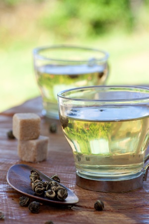 Green tea balls in tea infuser with sugar cubesの写真素材