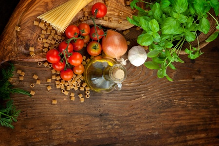 Fresh ingredients for italian cuisine: pasta, tomatoes, basil, olive oil, garlic and onionの写真素材