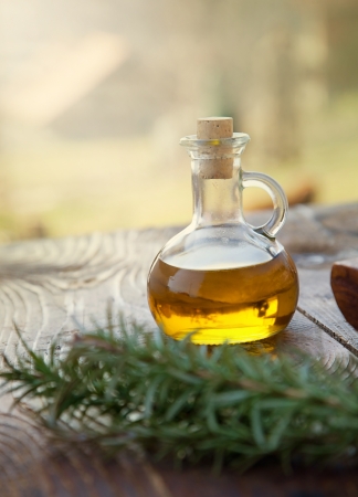 Extra virgin healthy Olive oil with fresh rosemary on rustic wooden backgroundの写真素材