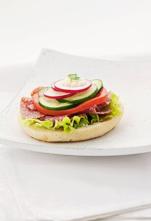 Delicious ham, cheese and salami sandwich with vegetables, lettuce, cherry tomatoesの写真素材