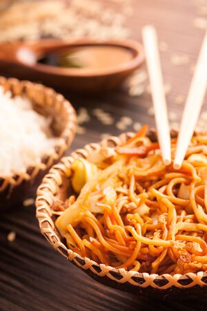 Chinese food. Egg noodles with chicken and vegetables, steamed rice and soy sauce.の写真素材