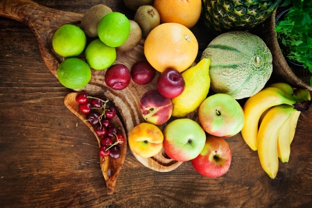 Organic Fruit variety on wood. Tropical exotic food concept. Pinneaple, pears,plums,kiwi,melon,grapefruit,aplles and bananas.の写真素材