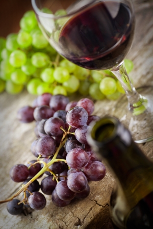Wine concept. Food and drink background with red wine, fresh grapes and wine bottleの写真素材
