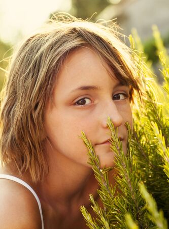 Beautiful little girl in summer rosemary garden. Child nature concept backgroundの写真素材