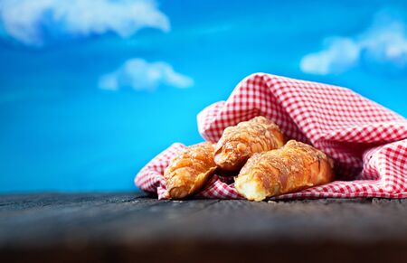 Freshly baked cheese buns on wooden background with blue sky in the background の写真素材