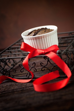 Chocolate cake. Souffle with red ribbot on wood.の写真素材