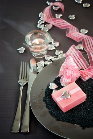 Restaurant series. Valentines day dinner with table setting in pink and gray and holiday elegant heart ornamentsの写真素材