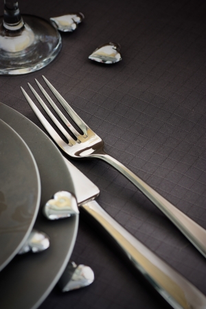 Restaurant series. Valentines day dinner with table setting in pink and gray and holiday elegant heart ornamentsの写真素材