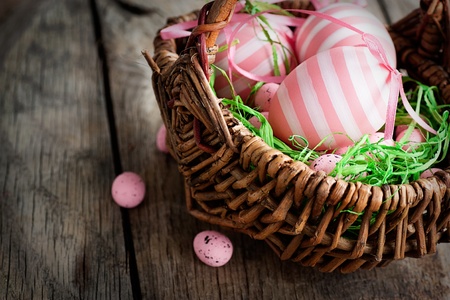 Colorful Easter holiday concept with pink eggs in wisker basket in natureの写真素材