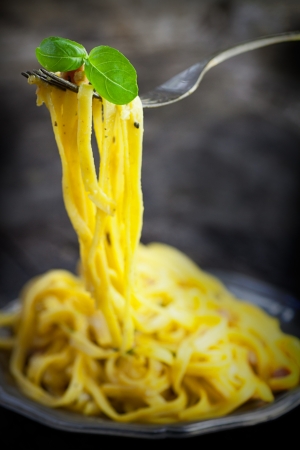 Italian cooking. Pasta spaghetti carbonara with ham, eggs and basil