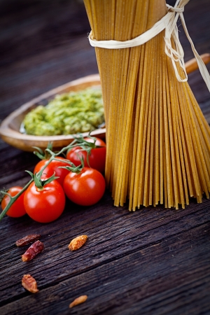 Italian cooking with whole wheat pasta, pesto sauce and ingredientsの写真素材