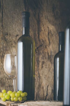 Wine. Glass of white wine in wine cellar. Old white wine on wood.の写真素材