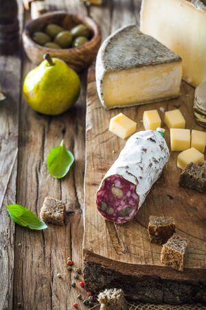 Cheese and Salami. Variety od cold cuts. Cheese on wood. Types of cheese and sausagesの写真素材