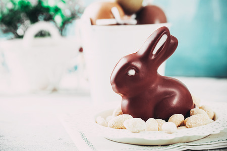 Easter. Chocolate  Eggs and bunny on Easter table. Tulips in vase. Easter setting  on tableの写真素材
