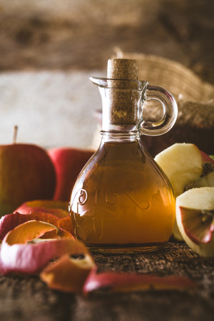 Apple vinegar. Bottle of apple organic vinegar on wooden background. Healthy organic food.の写真素材