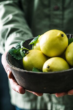 Organic fruit. Farmers hands with freshly harvested fruit. Fresh organic lemons.の写真素材