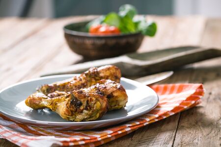 Roasted chicken legs with fresh vegetables and herbsの写真素材