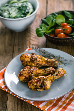Roasted chicken legs with fresh vegetables and herbsの写真素材