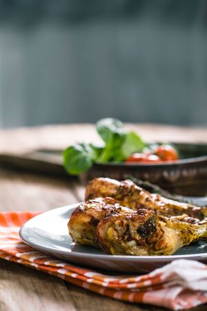 Roasted chicken legs with fresh vegetables and herbsの写真素材