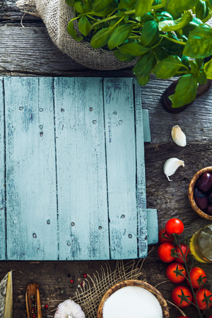 Wooden planks with food. Olives, basil, tomatoes and ingredients on woodの写真素材