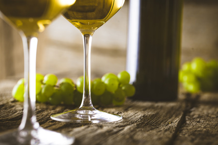 Wine. Glass of white wine in wine cellar. Old white wine on wood.の写真素材