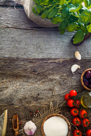 Wooden planks with food. Olives, basil, tomatoes and ingredients on woodの写真素材