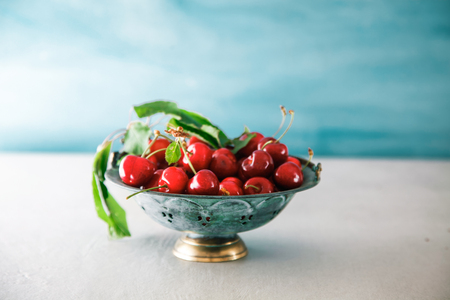 Fresh cherries on blue background. Fresh organic fruit. Red cherriesの写真素材