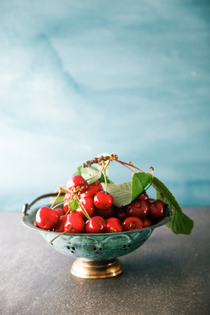 Fresh cherries on blue background. Fresh organic fruit. Red cherriesの写真素材