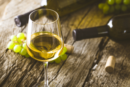 Wine. Glass of white wine in wine cellar. Old white wine on wood.の写真素材