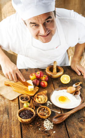 Baking concept background. Baker with ingredients for pastry desserts. Apples, lemon, sugar, walnutsの写真素材