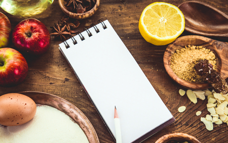 Baking background with paper for notes. Christmas and winter  cookies ingredients.Baking pastry and cookies: apples, spices, sugar, eggs on woodの写真素材