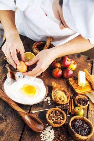 Baking concept background. Baker with ingredients for pastry desserts. Apples, lemon, sugar, walnutsの写真素材