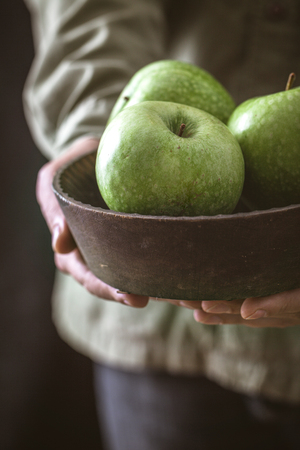 Organic fruit. Farmers hands with freshly harvested fruit. Fresh organic applesの写真素材