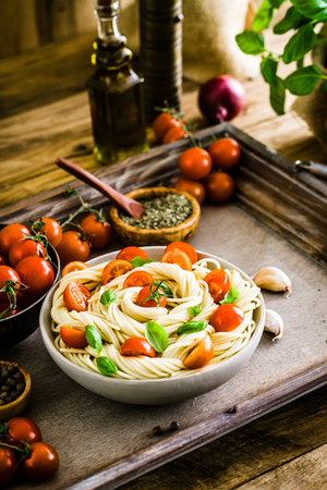 Italian cuisine. Pasta with olive oil, garlic, basil and tomatoes. Spaghetti with tomatoesの写真素材