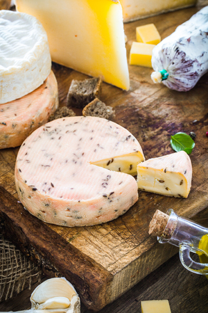 Cheese on wood. Types of cheese and herbs on woodの写真素材