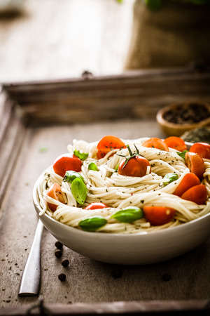 Italian cuisine. Pasta with olive oil, garlic, basil and tomatoes. Spaghetti with tomatoesの写真素材