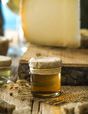 Honey on wood. Organic honey and cheese in vintage settingの写真素材