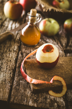 Apple vinegar. Bottle of apple organic vinegar on wooden background. Healthy organic food.の写真素材