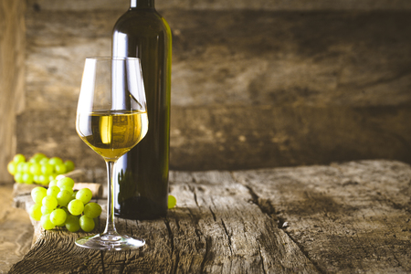 Wine. Glass of white wine in wine cellar. Old white wine on wood.の写真素材