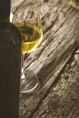 Wine. Glass of white wine in wine cellar. Old white wine on wood.の写真素材