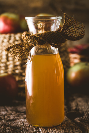 Apple vinegar. Bottle of apple organic vinegar on wooden background. Healthy organic food.の写真素材
