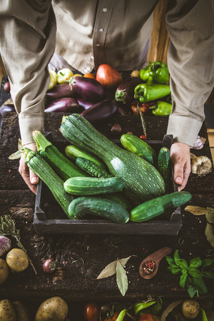 Organic vegetables. Farmers hands with freshly harvested vegetables. Fresh organic zucchini.の写真素材